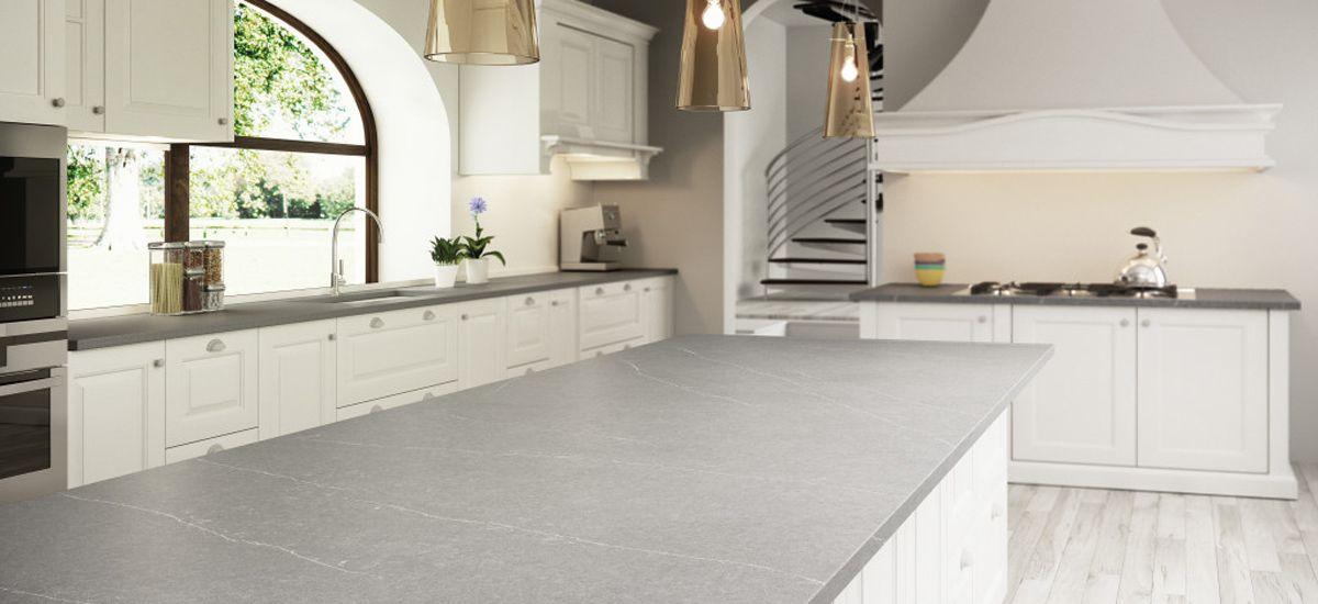 Silestone graue Arbeitsplatte in Landhausküche mit weißen Schränken und Pendelleuchten